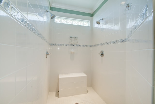 bathroom with crown molding and a tile shower