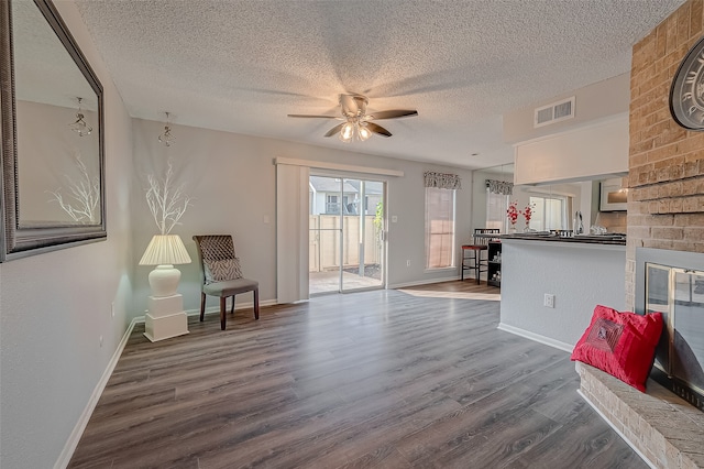 living room with ceiling fan, hardwood / wood-style flooring, beverage cooler, and a textured ceiling