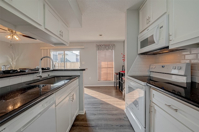 kitchen with dark wood-type flooring, sink, white cabinets, backsplash, and white appliances