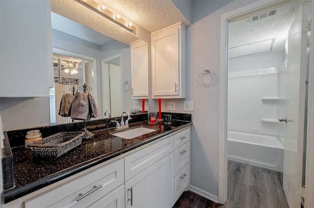 bathroom with a textured ceiling, vanity, and hardwood / wood-style flooring