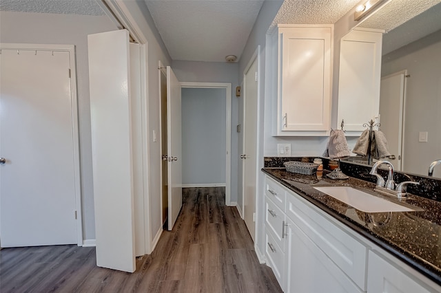 bathroom with wood-type flooring, a textured ceiling, and vanity