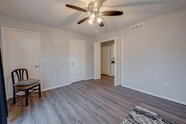 interior space with light hardwood / wood-style floors, ceiling fan, and a textured ceiling