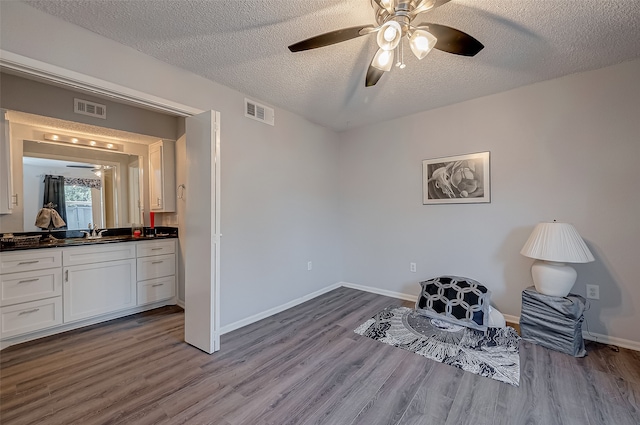 sitting room featuring a textured ceiling, light hardwood / wood-style floors, and ceiling fan