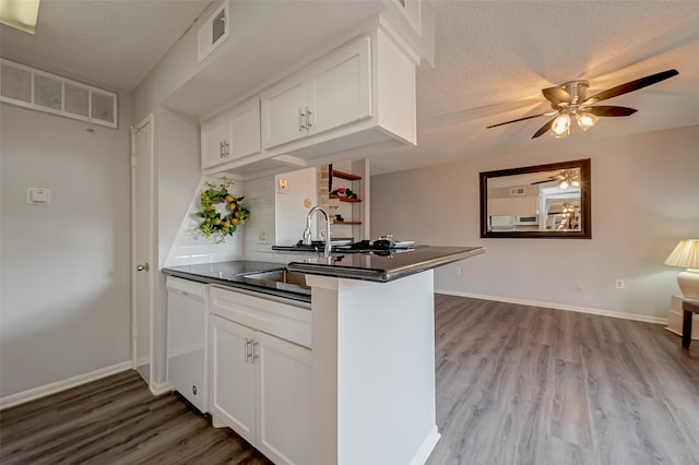 kitchen with white cabinets, kitchen peninsula, white dishwasher, light wood-type flooring, and ceiling fan