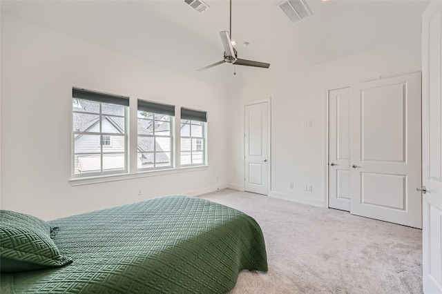 bedroom with ceiling fan, vaulted ceiling, and light colored carpet