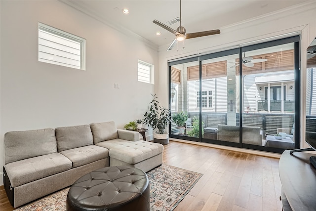 living room featuring ornamental molding, light hardwood / wood-style flooring, and ceiling fan