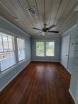 unfurnished room with dark wood-type flooring, wooden ceiling, and ceiling fan