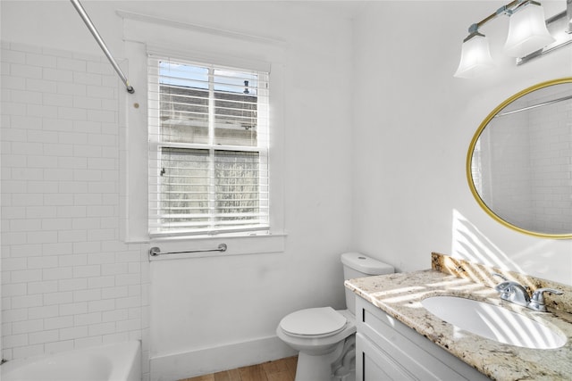 full bathroom with vanity, hardwood / wood-style flooring, toilet, and tiled shower / bath