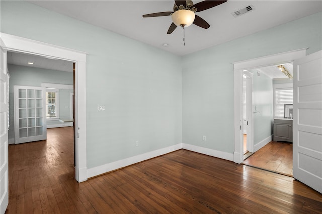 unfurnished bedroom featuring dark hardwood / wood-style flooring, multiple windows, and ceiling fan