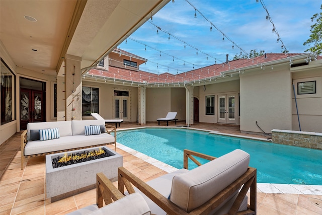 view of swimming pool with an outdoor living space with a fire pit, a patio, and french doors