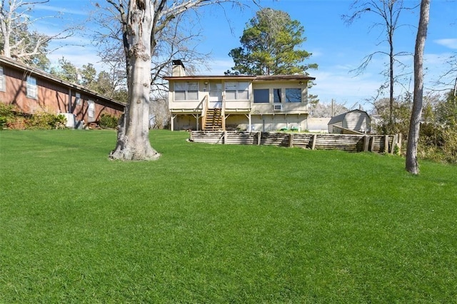 back of property with a wooden deck and a lawn