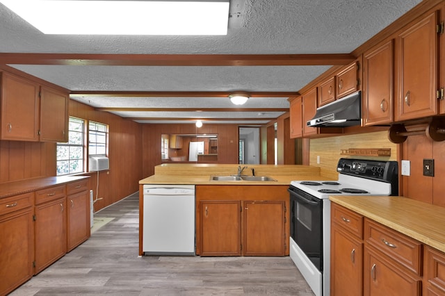 kitchen featuring white appliances, sink, kitchen peninsula, light hardwood / wood-style floors, and a textured ceiling