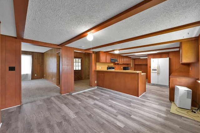 kitchen featuring kitchen peninsula, light colored carpet, a textured ceiling, beam ceiling, and white fridge with ice dispenser