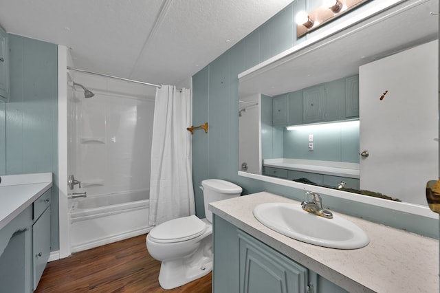 full bathroom featuring shower / bath combo with shower curtain, a textured ceiling, toilet, vanity, and hardwood / wood-style flooring