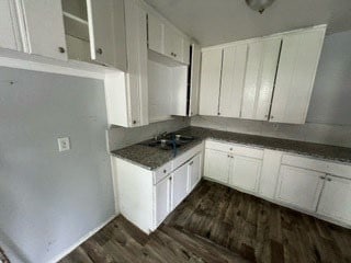 kitchen with white cabinetry, sink, dark wood-type flooring, and dark stone countertops