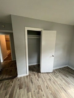 unfurnished bedroom featuring hardwood / wood-style flooring and a closet