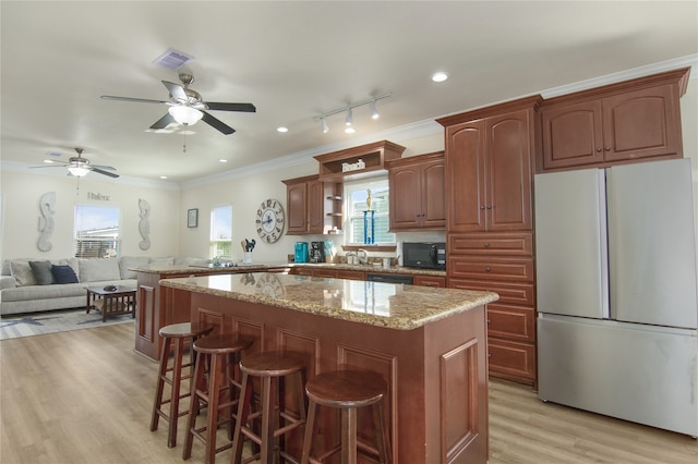 kitchen with light hardwood / wood-style flooring, crown molding, a center island, white fridge, and ceiling fan