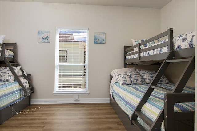 bedroom with multiple windows and hardwood / wood-style flooring