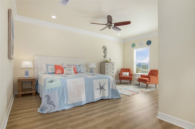 bedroom with light hardwood / wood-style floors, crown molding, and ceiling fan