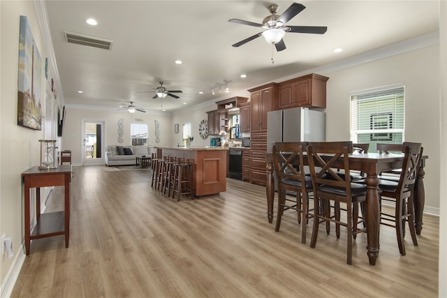 dining space with crown molding, ceiling fan, and light hardwood / wood-style floors