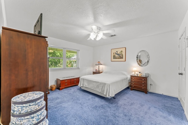 bedroom with a textured ceiling, carpet floors, ceiling fan, and visible vents