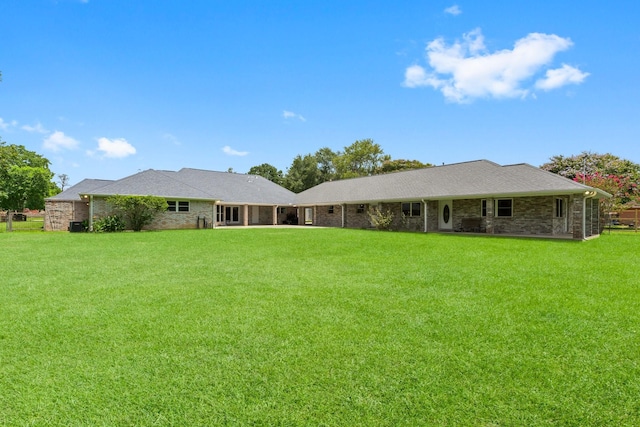 rear view of property featuring a lawn