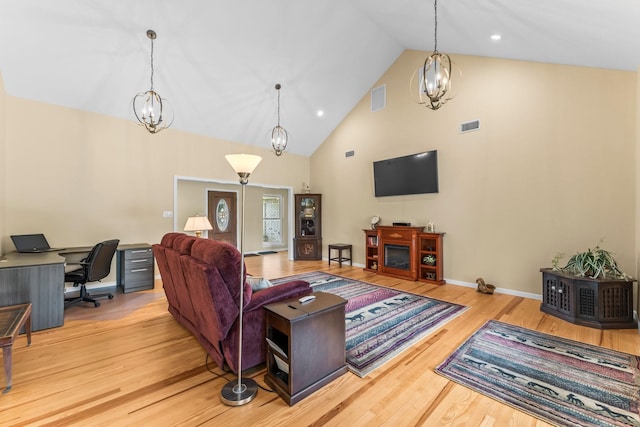 living area featuring a chandelier, wood finished floors, and visible vents