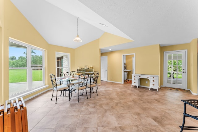 dining area featuring light tile patterned floors and lofted ceiling