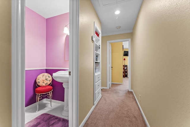 corridor featuring carpet floors, attic access, and baseboards