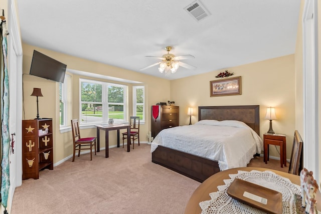 bedroom with a ceiling fan, visible vents, light carpet, and baseboards