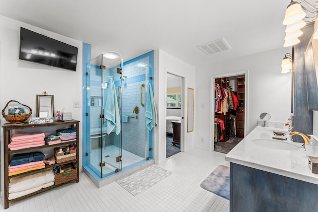 full bathroom featuring visible vents, a sink, a shower stall, and a spacious closet