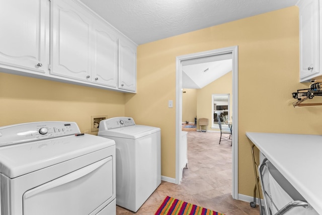 washroom with cabinet space, baseboards, separate washer and dryer, and a textured ceiling