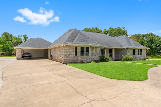 single story home featuring an attached garage, a shingled roof, concrete driveway, and a front yard