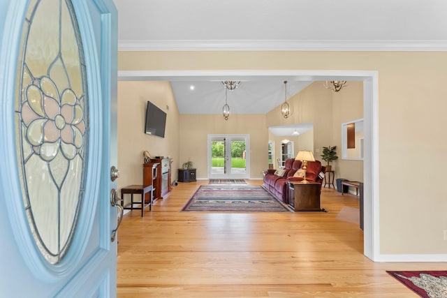 foyer entrance featuring french doors, ornamental molding, light wood-type flooring, and baseboards