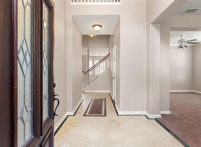 carpeted foyer entrance featuring ceiling fan