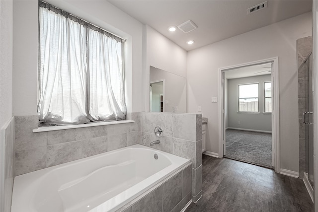 bathroom with hardwood / wood-style flooring and separate shower and tub