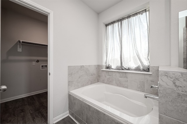 bathroom featuring hardwood / wood-style flooring and tiled bath