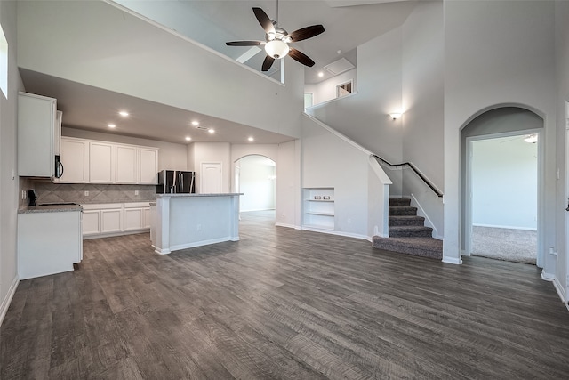 kitchen featuring stainless steel fridge with ice dispenser, white cabinetry, a high ceiling, a kitchen island, and ceiling fan