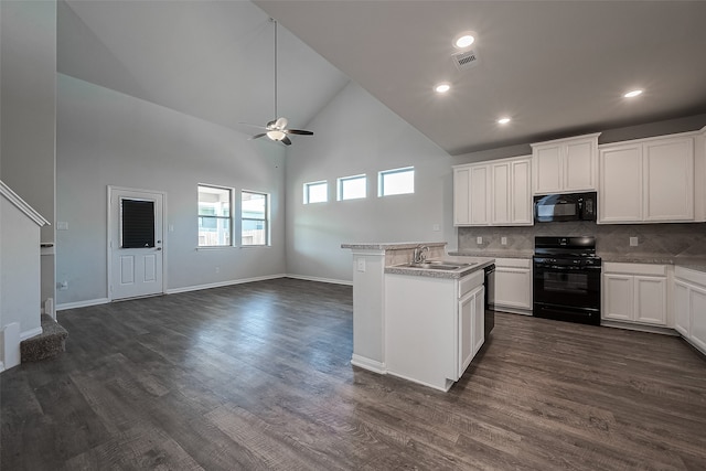 kitchen with tasteful backsplash, black appliances, sink, dark hardwood / wood-style floors, and high vaulted ceiling