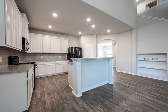 kitchen with dark wood-type flooring, white cabinetry, a kitchen island, and stainless steel appliances