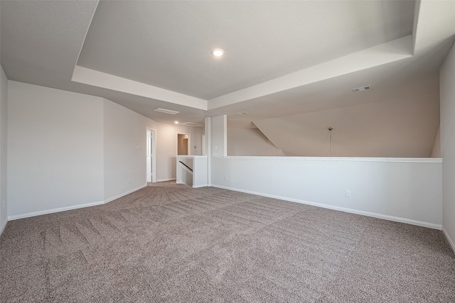 empty room featuring carpet and a tray ceiling