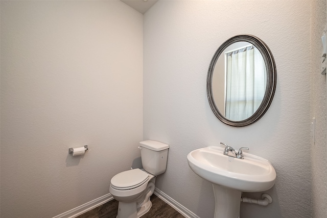 bathroom with hardwood / wood-style flooring, toilet, and sink