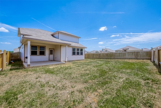 rear view of house with a patio and a lawn