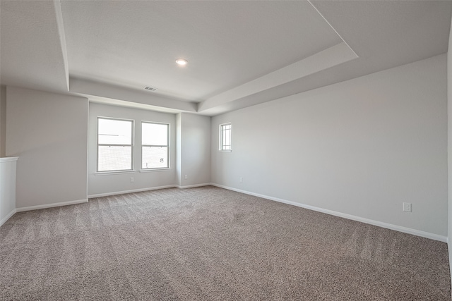 unfurnished room featuring carpet floors and a raised ceiling