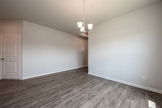 spare room with a notable chandelier and hardwood / wood-style floors