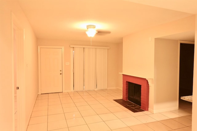 unfurnished living room featuring ceiling fan, a brick fireplace, and light tile patterned flooring