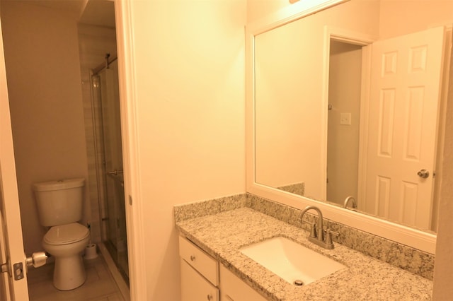 bathroom with a shower with door, toilet, vanity, and tile patterned floors