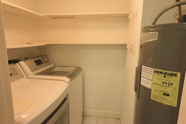 washroom with washer and clothes dryer, light tile patterned floors, and electric water heater