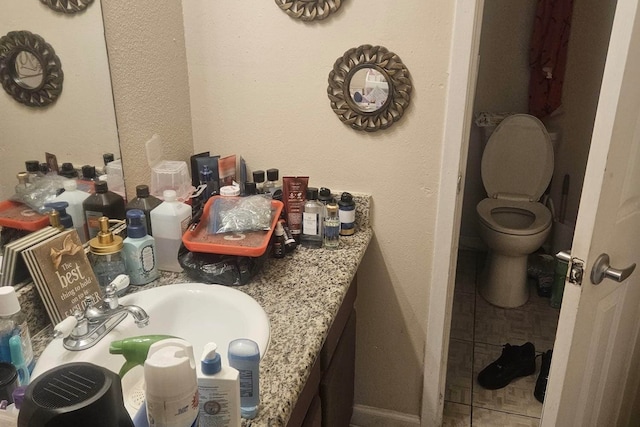 bathroom featuring tile patterned floors, vanity, and toilet