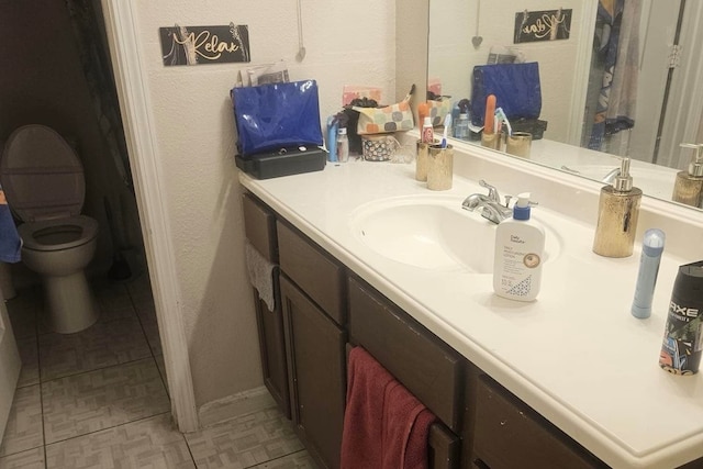 bathroom with tile patterned floors, vanity, and toilet